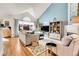 Bright living room featuring vaulted ceiling, hardwood floors, comfortable seating, and view of backyard at 12420 E Iliff Pl, Aurora, CO 80014