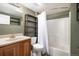 Functional bathroom features shower-tub combo, vanity, shelving, and neutral color palette at 2749 Pemberly Ave, Highlands Ranch, CO 80126