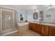 This bathroom offers a glass shower, large tub, and double sink with wooden cabinetry at 2749 Pemberly Ave, Highlands Ranch, CO 80126