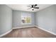 Light-filled bedroom with hardwood floors, large window, and modern ceiling fan at 2749 Pemberly Ave, Highlands Ranch, CO 80126