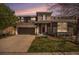 Charming two-story home with a well-maintained front yard, stone accents, and an attached two-car garage at dusk at 2749 Pemberly Ave, Highlands Ranch, CO 80126