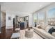 Bright living room featuring wood floors, neutral sofa, accent rug, and arched doorway leading into the kitchen at 2749 Pemberly Ave, Highlands Ranch, CO 80126