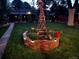 Charming backyard with lush green lawn, windmill decoration, and ambient lighting at night at 2989 S Corona St, Englewood, CO 80113