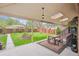 Covered backyard patio with wood table, outdoor grill, and view of the landscaped yard at 2989 S Corona St, Englewood, CO 80113