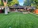 Expansive backyard with a covered patio, windmill feature, and well-manicured lawn at 2989 S Corona St, Englewood, CO 80113
