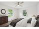 Bright bedroom with wood floors, ceiling fan, and two windows overlooking the yard at 2989 S Corona St, Englewood, CO 80113