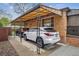 Attached carport with two parked vehicles, decorative ironwork, and access to the house at 2989 S Corona St, Englewood, CO 80113