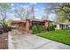 Charming brick home featuring a well-manicured lawn, covered carport, and an inviting front porch at 2989 S Corona St, Englewood, CO 80113