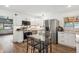 Modern kitchen with stainless steel appliances, white cabinetry, and a glass-top dining table at 2989 S Corona St, Englewood, CO 80113