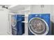 Bright laundry room features a front-load washer and dryer set and white wall shelving at 2989 S Corona St, Englewood, CO 80113