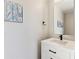 Elegant half-bathroom featuring a modern vanity with clean lines, black hardware, and stylish wall decor at 3017 W 53Rd Ave, Denver, CO 80221