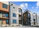 Modern townhome exterior showcasing mixed material facade, balconies, and landscaped entryways under a bright sky at 3017 W 53Rd Ave, Denver, CO 80221