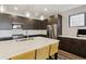 Modern kitchen featuring stainless steel appliances, dark cabinetry, pendant lighting, and quartz countertops at 3017 W 53Rd Ave, Denver, CO 80221