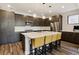 Modern kitchen with a large island, stainless steel appliances, dark wood cabinets, and pendant lighting at 3017 W 53Rd Ave, Denver, CO 80221
