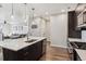 Spacious kitchen featuring stainless steel appliances, modern pendant lights, and island with stone countertops at 3017 W 53Rd Ave, Denver, CO 80221