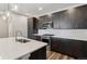 Modern kitchen featuring stainless steel appliances, a spacious island, sleek countertops, and dark wood cabinetry at 3017 W 53Rd Ave, Denver, CO 80221