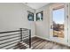 Upper level landing featuring modern railing, two corner windows with plants, and access to balcony at 3017 W 53Rd Ave, Denver, CO 80221