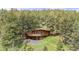 Aerial view of a wooded home with a wooden deck, nestled in a lush forest setting at 4923 Snowberry Ln, Evergreen, CO 80439