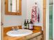 Rustic bathroom with wooden vanity, white sink, and decorative towel rack with bright-colored towels at 4923 Snowberry Ln, Evergreen, CO 80439