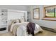 Comfortable bedroom with built-in shelving, and window to outside greenery at 4923 Snowberry Ln, Evergreen, CO 80439