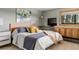 Comfortable bedroom with gray walls, a TV, a large window, and a full size bed dressed with decorative pillows at 4923 Snowberry Ln, Evergreen, CO 80439