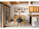 Dining area with wooden table and chairs next to the kitchen with light and bright decor at 4923 Snowberry Ln, Evergreen, CO 80439