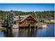 Stunning waterfront home with stone accents, a deck, and captivating lake views at 4923 Snowberry Ln, Evergreen, CO 80439