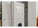 Efficient laundry room with stacked washer and dryer, and adjacent storage space at 4923 Snowberry Ln, Evergreen, CO 80439