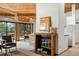Open living space with fireplace and access to a dining area, enhanced by natural light and wood accents at 4923 Snowberry Ln, Evergreen, CO 80439