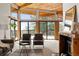 Comfortable living room with sliding glass doors, light carpet, wooden ceiling, and a cozy fireplace at 4923 Snowberry Ln, Evergreen, CO 80439