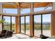 Bright living area featuring expansive windows and scenic views that connect to an outdoor deck at 4923 Snowberry Ln, Evergreen, CO 80439