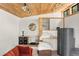 Cozy living room boasts bright, natural light, wooden ceiling and unique round window at 4923 Snowberry Ln, Evergreen, CO 80439