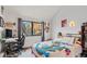 Modern bedroom with a playful comforter, desk, and large window offering natural light and outdoor views at 343 W Lehow Ave # 22, Englewood, CO 80110