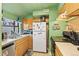 Functional kitchen with wood cabinets, stainless steel sink, and appliances against a vibrant green backdrop at 343 W Lehow Ave # 22, Englewood, CO 80110