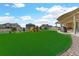 Large backyard with vibrant artificial turf, a playset, and a covered patio, perfect for relaxation and recreation at 20783 E 50Th Pl, Denver, CO 80249