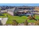 A large backyard with a manicured lawn, covered patio, and playset set against a backdrop of nearby houses at 20783 E 50Th Pl, Denver, CO 80249