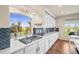 Kitchen with gas cooktop, white cabinets, and herringbone backsplash at 20783 E 50Th Pl, Denver, CO 80249