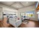 Open-concept living room with coffered ceilings, wood floors, a kitchen with an island, and ample natural light from large windows at 20783 E 50Th Pl, Denver, CO 80249