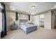 Spacious main bedroom with neutral tones, tray ceiling, and barn door to the bathroom at 20783 E 50Th Pl, Denver, CO 80249