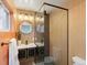 Modern bathroom featuring a tiled shower with glass door and round mirrors at 10109 W 68Th Ave, Arvada, CO 80004