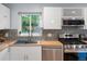 Close-up view of the kitchen's sink, stove, and tiled backsplash area at 10109 W 68Th Ave, Arvada, CO 80004