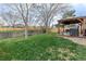 Large backyard with green grass, wood fence, covered patio, and a Traeger smoker perfect for outdoor entertaining at 9340 W Burgundy Ave, Littleton, CO 80123