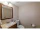 Cozy powder room with a small sink, dark wood mirror frame and toilet at 9340 W Burgundy Ave, Littleton, CO 80123
