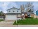Charming two-story home with a well-maintained lawn and a two-car garage at 9340 W Burgundy Ave, Littleton, CO 80123