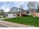 Lovely home featuring a green lawn, brick accents, and an attached two-car garage at 9340 W Burgundy Ave, Littleton, CO 80123