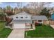 Well-maintained two-story home boasts brick accents, gray siding, an attached two-car garage, and a manicured lawn at 9340 W Burgundy Ave, Littleton, CO 80123