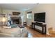 Cozy living room featuring a brick fireplace, hardwood floors, and comfortable seating at 9340 W Burgundy Ave, Littleton, CO 80123