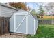 A wooden shed painted light blue with white trim sits on a gravel bed in a well-maintained backyard at 9340 W Burgundy Ave, Littleton, CO 80123