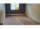Bedroom with blue accent wall, beige carpeting, and a window with natural light at 8828 E Florida Ave # 103, Denver, CO 80247