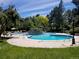 Community swimming pool surrounded by lush greenery and mature trees, perfect for relaxation at 8828 E Florida Ave # 103, Denver, CO 80247